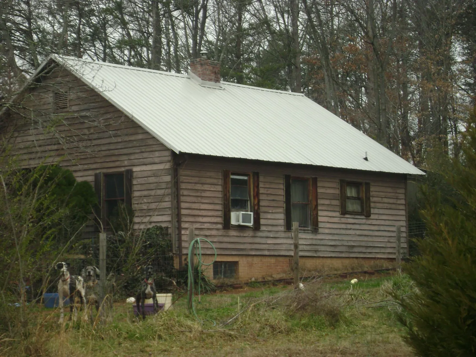White metal roof on an old wood sided farmhouse, from a Metal Roof Installation job in Waldorf
